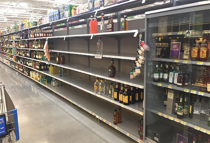 Почти пустые полки в отделе алкоголя супермаркета
