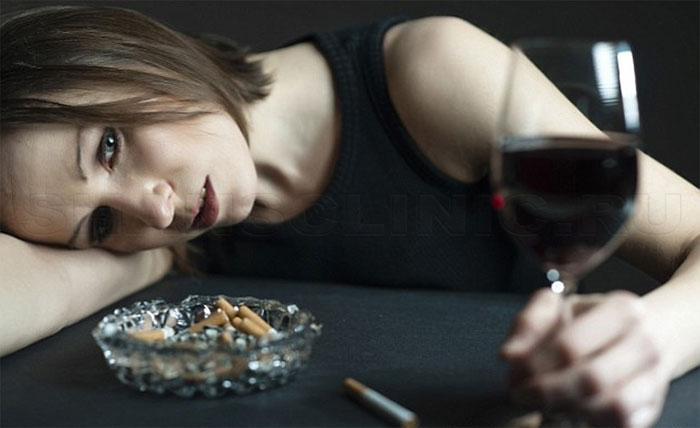 Девушка пьет вино и курит сигареты