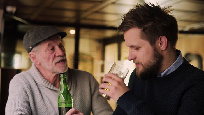 Пожилой и молодой человек употребляют алкоголь