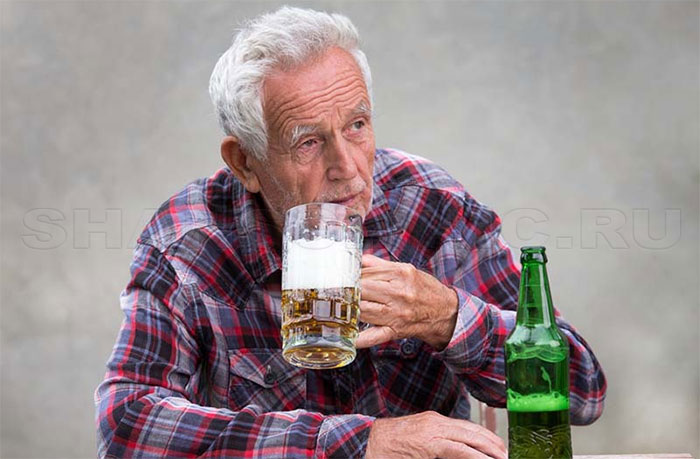 Пожилой мужчина пьет пиво